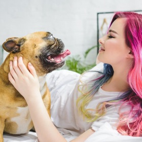 a person lying in bed with a dog